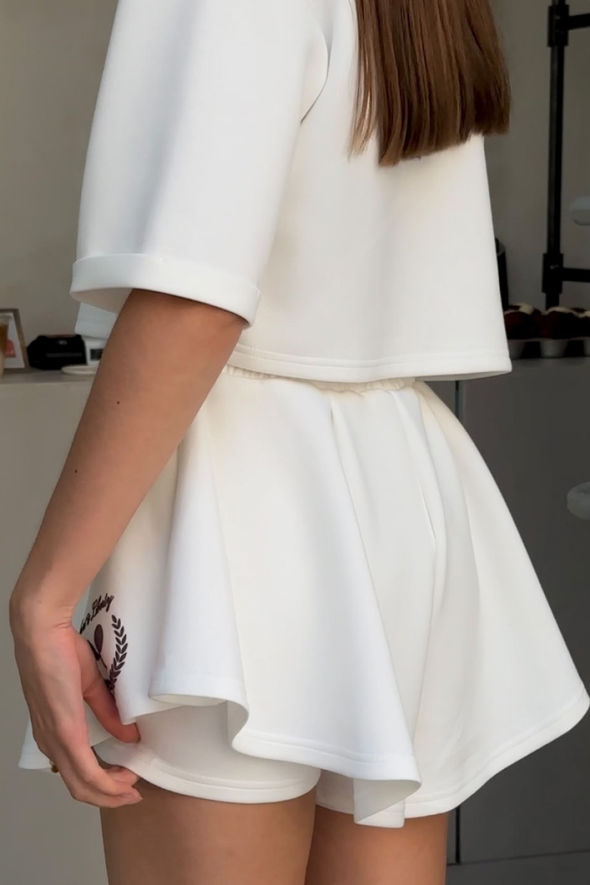 Молочный спортивный костюм с укороченной футболкой и юбкой-шортами LIBERTY